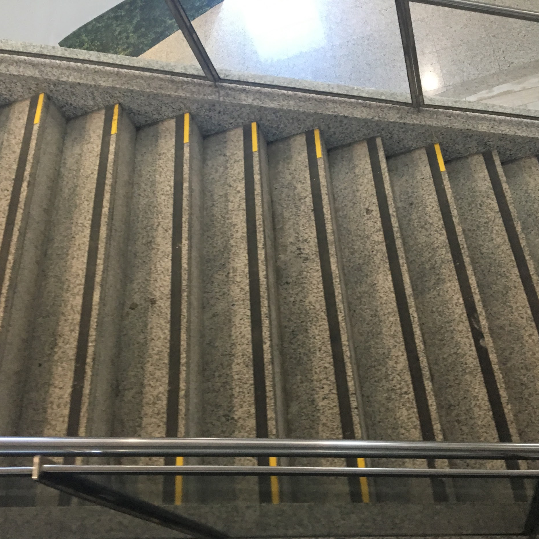 Escada com piso antiderrapante, sinalização visual nas bordas dos degraus e corrimão de apoio lateral, garantindo segurança no deslocamento.