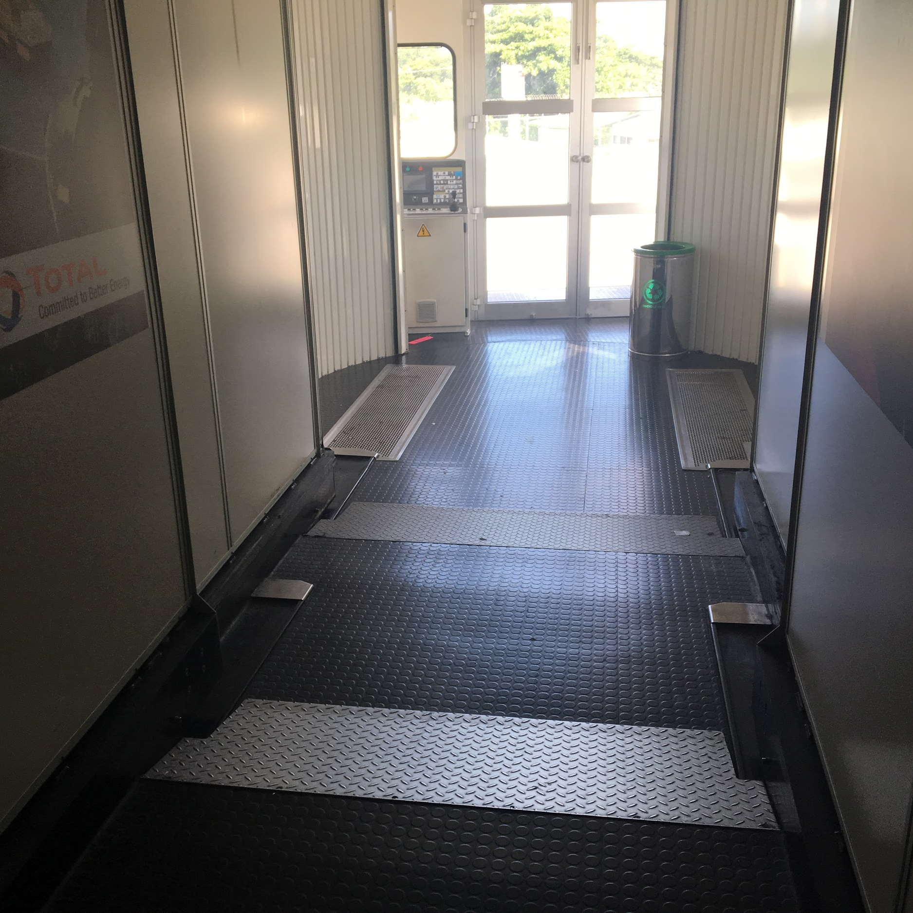 Piso metálico com superfície antiderrapante e desníveis suaves na área de embarque do finger (ponte de embarque) que conecta à aeronave.