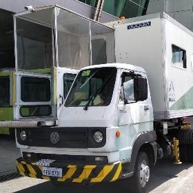 Caminhão modelo ambulift adaptado para transporte de passageiros com mobilidade reduzida entre o solo e a aeronave.